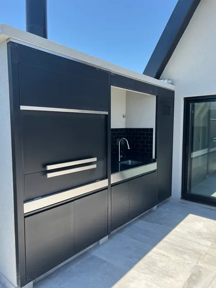 Cocina exterior moderna con gabinetes negros — proyecto DEPTO MARTINEZ, por Estudio Grupo 32, en Martínez