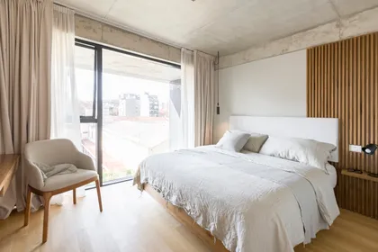 Dormitorio moderno con ventana al piso, pared de madera y hormigón — proyecto Nicaragua, por SRMD Arquitectura, en Palermo