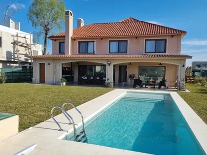 Casa moderna con piscina y patio, fachada blanca y techo de tejas — proyecto Casa El Rebenque, por Arq. Leonardo  De Lorenzi , en Canning