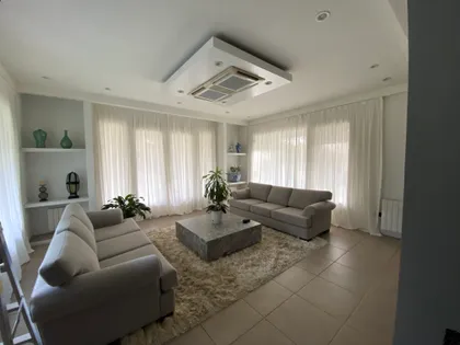Living moderno con sofá curvo, alfombra de pelo largo y mucha luz natural — proyecto Saint Thomas norte, por Vorh, en Canning