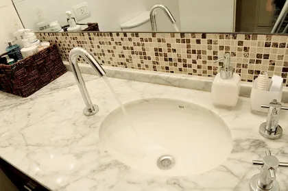 Baño moderno con mesada de mármol y espejo circular — proyecto Marcelo T de Alvear, por Rioja Arquitectura, en Recoleta