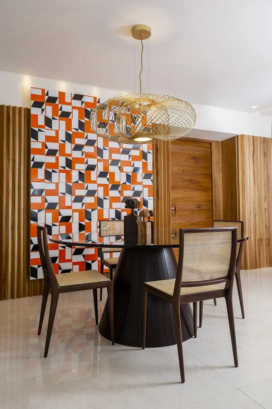 Comedor contemporaneo con mesa redonda negra y muro geometrico naranja — proyecto Apartamento TS, por Patrícia Marinho Arquitetura 