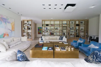 Living moderno con estanterías de pared a pared y muebles coloridos — proyecto Casa H, por Estudio Dado, en Belgrano