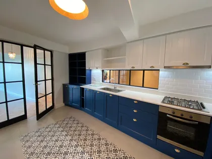Cocina moderna con muebles azules y blancos y detalles industriales — proyecto Casa Olleros, por Gutman+Lehrer Arquitectas, en CABA