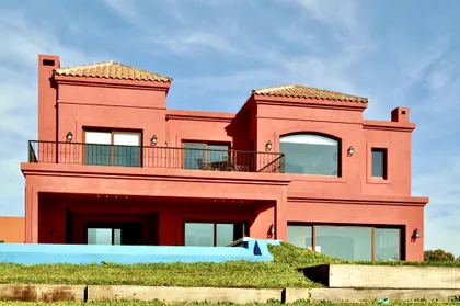 Casa terracota estilo mediterráneo con ventanales y balcones — proyecto San Marcos 2, por Marconi Silva Arquitectos, en Benavidez