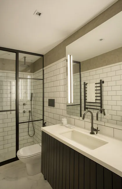 Baño moderno con mesada de mármol, espejo iluminado y ducha vidriada — proyecto JG House, por Studio Ro-ca