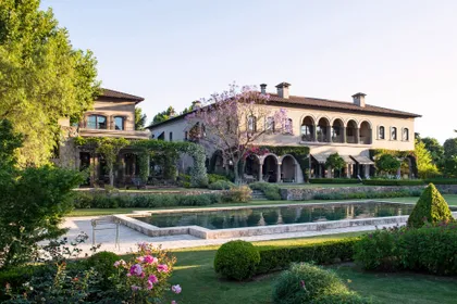 Villa de piedra con arcadas, pileta y jardín neoclásico al atardecer — proyecto Casa Toscana , por Estudio Du
