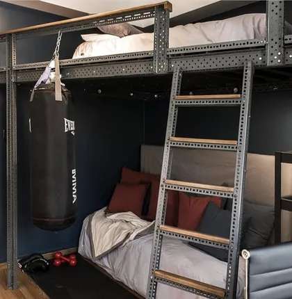 Habitación industrial con cama alta, saco de boxeo y estanterías metálicas — proyecto Las Heras , por Claraboia , en Recoleta