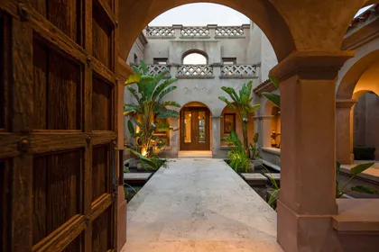 Fachada mediterránea con patio interior y puertas de madera — proyecto Casa MJ, por Ricardo Pereyra Iraola