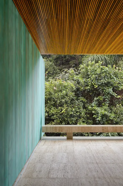 Balcón moderno con pared verde, techo de madera y vista al bosque — proyecto Casa Asa, por Studio Guilherme Torres