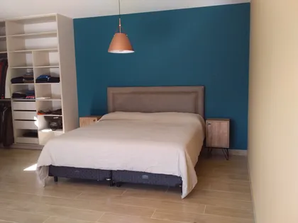 Dormitorio moderno con pared azul teal y armario blanco — proyecto Siete soles, por Design & Living, en Córdoba