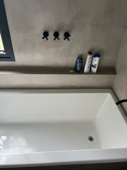Baño moderno con paredes de microcemento y bañera exenta blanca — proyecto CASA RZ, por SEDE Arq., en Pilar