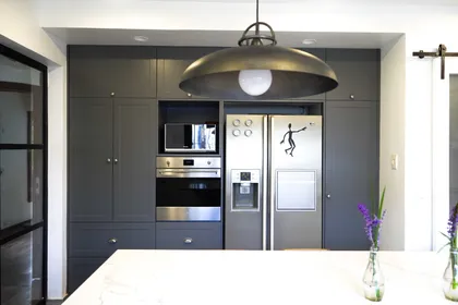 Cocina moderna con gabinetes grises y lámpara colgante grande — proyecto Obra Isabel la Católica P, por Arq. Lourdes Yarade Saravia, en San Isidro
