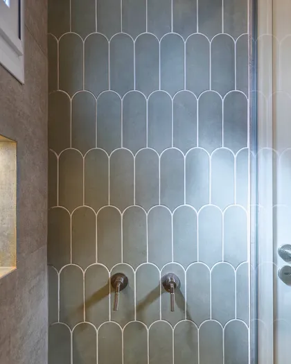 Baño moderno con azulejos curvos verdes y grifería doble — proyecto Quesada, por Blue Rabbit Design, en Núñez