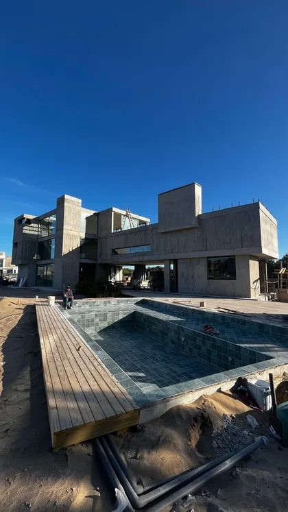 Casa moderna con pileta revestida en azul y deck de madera clara — proyecto CASA CE 059 - COSTA ESMERALDA, por Carolina Depetris, en Pinamar