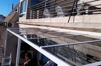 Obra de terraza con toldo de vidrio y metal — proyecto Alero con vidrio Blindex color, por Cristalcenter, en Palermo