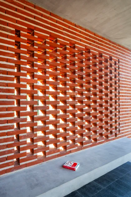 fachada moderna con muro de ladrillo a la vista y banco de hormigón — proyecto Casa FLOIG, por V2 Arquitectos, en Villa Elisa