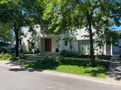 Fachada moderna con vegetación exuberante y grandes ventanales — proyecto Ayres LG, por Baires Green, en San Isidro