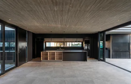 Cocina moderna minimalista con isla y techo de hormigón visto — proyecto Casa ROMA, por V2 Arquitectos, en City Bell