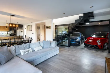 Living moderno con autos deportivos integrados y escalera flotante — proyecto Casa ALM57, por EZ architects, en Canning