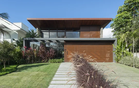 Casa moderna con fachada madera, jardín y deck de entrada — proyecto Casa M.J., por Ruschel Arquitetura e Urbanism