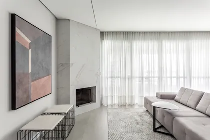 Living moderno con chimenea integrada y sofá seccional gris, mucha luz natural — proyecto Apartamento LN, por Boscardin Corsi Arquitetura
