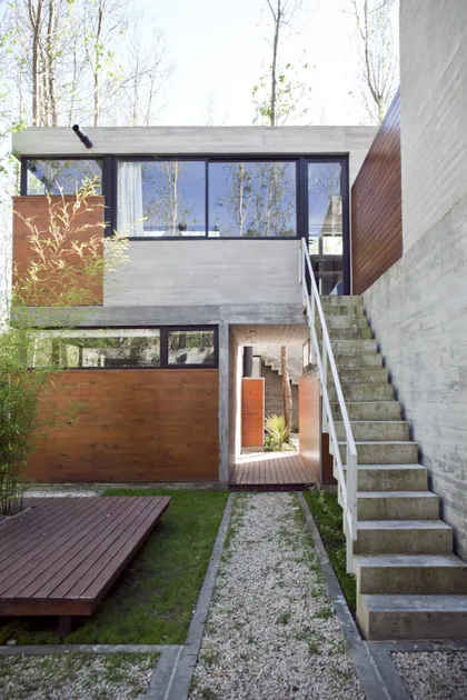 Casa contemporánea de dos plantas con fachada mixta hormigón y madera — proyecto Conjunto Las Gaviotas, por Luciano Kruk