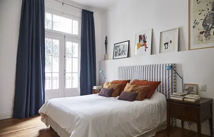 Dormitorio moderno con paneles grises y cortinas oscuras — proyecto BERUTI 2, por Estudio Trama, en Palermo
