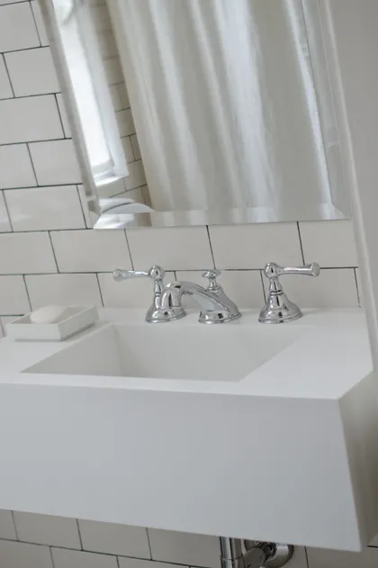 Baño moderno con lavabo de pedestal blanco, grifería cromada y azulejos blancos — proyecto Dpto LH, por Estudio Dado, en Recoleta