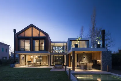 Casa moderna con grandes ventanales e iluminacion nocturna junto a pileta — proyecto Casa Carol, por Estudio Lak, en Club Newman