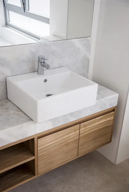 baño moderno con vanitory de madera y mesada de mármol — proyecto Proyecto Beruti, por URBANO estudio, en Palermo