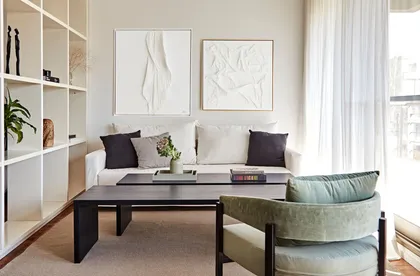 Living moderno con sofá gris, sillón verde y estanterías blancas — proyecto Proyecto Arboris, por URBANO estudio, en San Isidro