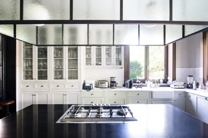 Cocina moderna blanca con isla central y grandes ventanales — proyecto Casa Toscana , por Estudio Du
