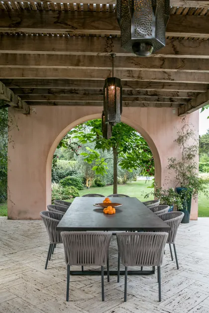 Quincho moderno con pergola, mesa negra y sillas de diseño — proyecto CasaLA, por Ricardo Pereyra Iraola 