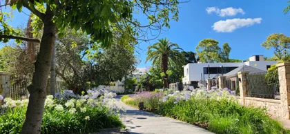 fachada moderna con vegetación exuberante y camino curvo — proyecto Finca Sarmiento, por Estudio Rifahi, en Martínez
