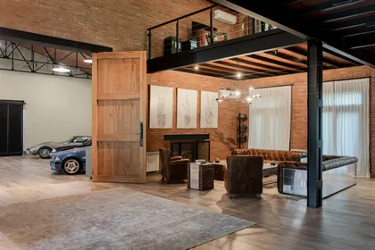 Living industrial moderno con doble altura y ladrillo expuesto — proyecto Loft y garage autos de colección , por Arq. Damian Fainzilber, en San Isidro