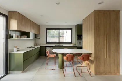 Cocina moderna con isla y banquetas naranjas — proyecto CASA CC, por Rastro Estudio, en San Isidro