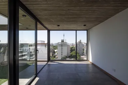 Living comedor moderno con vistas urbanas y hormigón visto — proyecto Terrazas de Saavedra, por DREI Arquitectura y Desarrollos, en La Plata