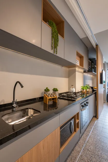 Cocina moderna con mesada negra, muebles blancos y detalles en madera natural — proyecto Brick 1, por Pricila Dalzochio