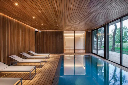 Pileta interior moderna con revestimientos de madera — proyecto Spa La Fantasía, por Mazzinghi Sanchez