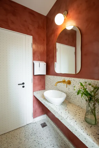 Baño moderno con paredes borgoña texturizadas y lavabo de mármol tipo terrazzo — proyecto Borja - Juncal, por Mgc.arq, en Buenos Aires