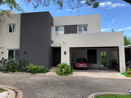 fachada moderna con volúmenes geométricos y garaje abierto — proyecto LA HORQUETA, por Fb Arqs, en San Isidro