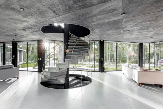 Amplio interior moderno con escalera caracol y hormigón expuesto — proyecto Casa Ameba, por MUCHTEK, en Cariló