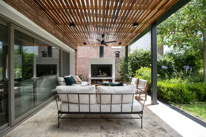Espacio exterior moderno con pérgola de madera y ladrillos vistos — proyecto Obra La Posta, por Arq. Lourdes Yarade Saravia, en Pilar