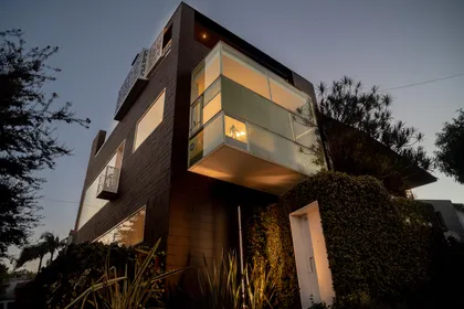 Fachada moderna con caja de vidrio en voladizo y pared verde — proyecto M4, por Etunez, en Buenos Aires