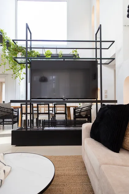 Living moderno con estanterías de metal negro y plantas colgantes — proyecto Casa Canning, por Gaby Alfonso, en Canning