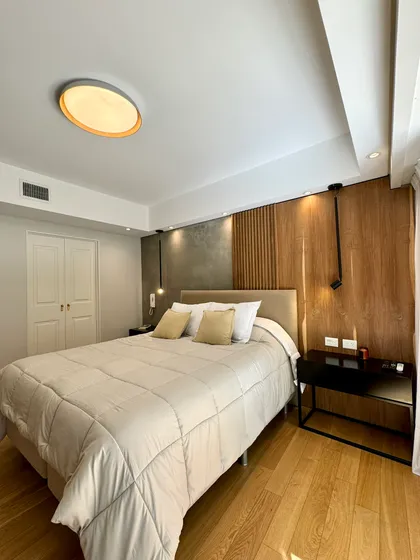 Dormitorio moderno con revestimiento de madera y luz indirecta — proyecto Olleros, por MDBK Arquitectura, en Belgrano