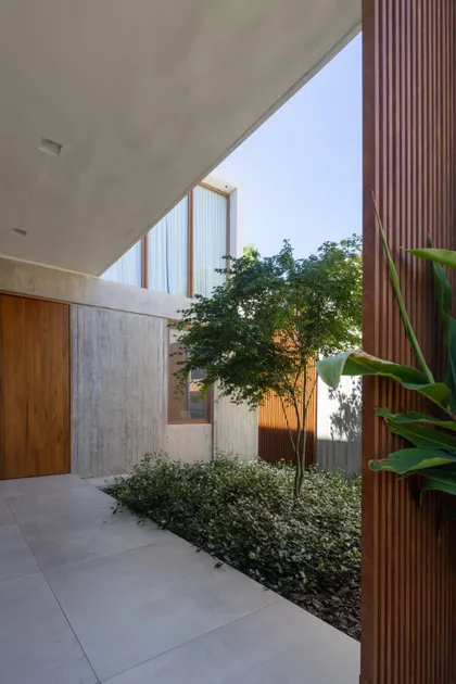 fachada moderna con madera, hormigón y patio interior — proyecto CASA OrAz, por Alfredo Orfila arquitectura, en San Isidro