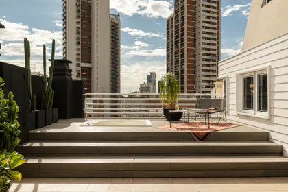 Terraza moderna con deck de madera y vista urbana — proyecto Proyecto Cabello, por Alejandra Nusenovich, en Buenos Aires
