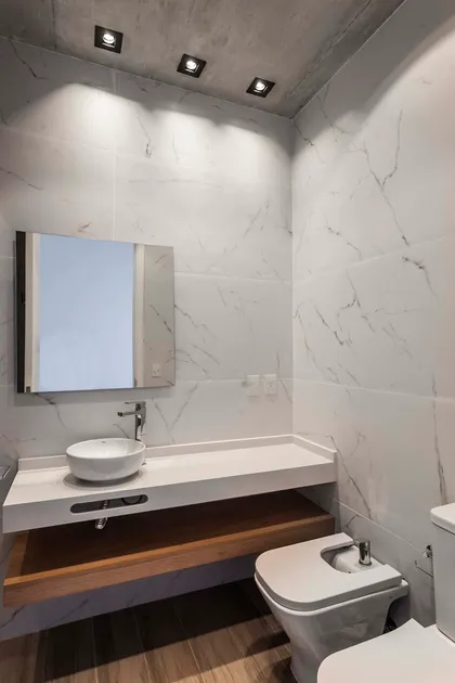 Baño moderno con paredes de mármol, vanitory flotante y suelo de madera — proyecto DISEÑO INTERIOR - CASA VISTAS, por FOCO_arquitectura&diseñointerior, en Belén de Escobar